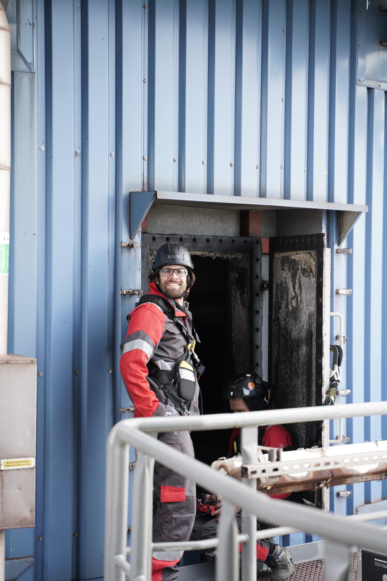 Smiling pilot at a boiler manway entry