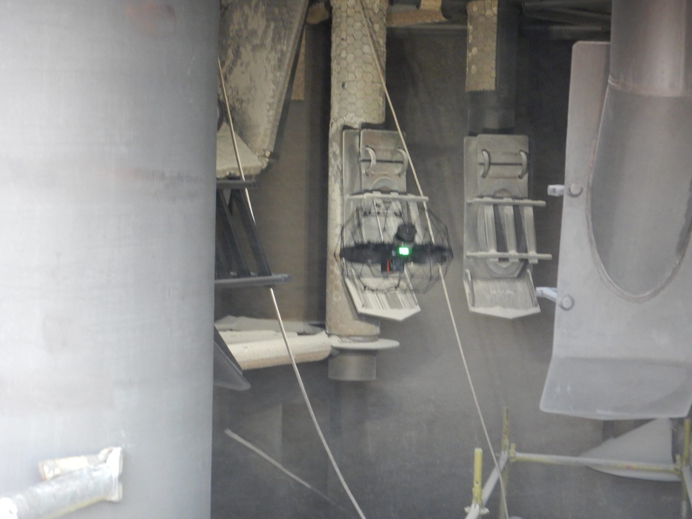 Caged drone flying inside a dusty vessel